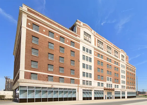 A seven story apartment building with red and white brick exterior.